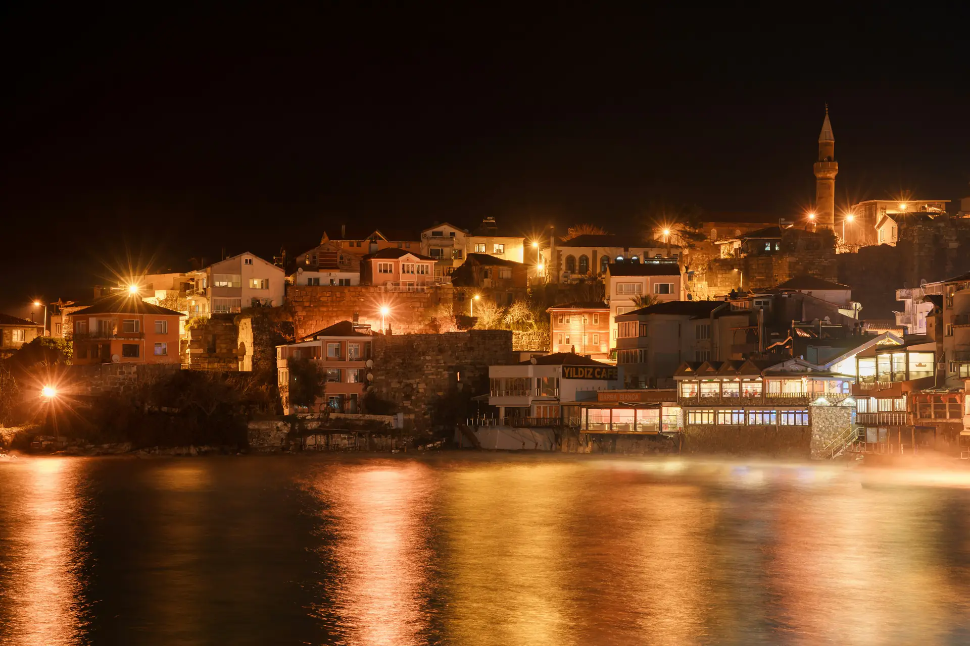 Gece ışıklarıyla Amasra kıyısı ve denizdeki yansımaları